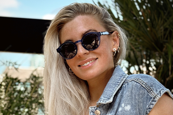 Smiling woman with sunglasses on a beach