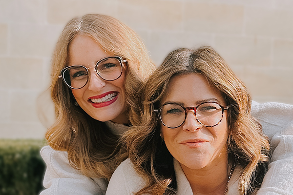 Two smiling women wearing glasses